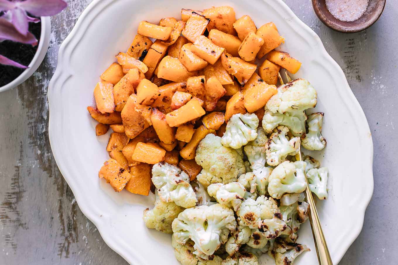 baked cauliflower and butternut squash side dish on a wood table