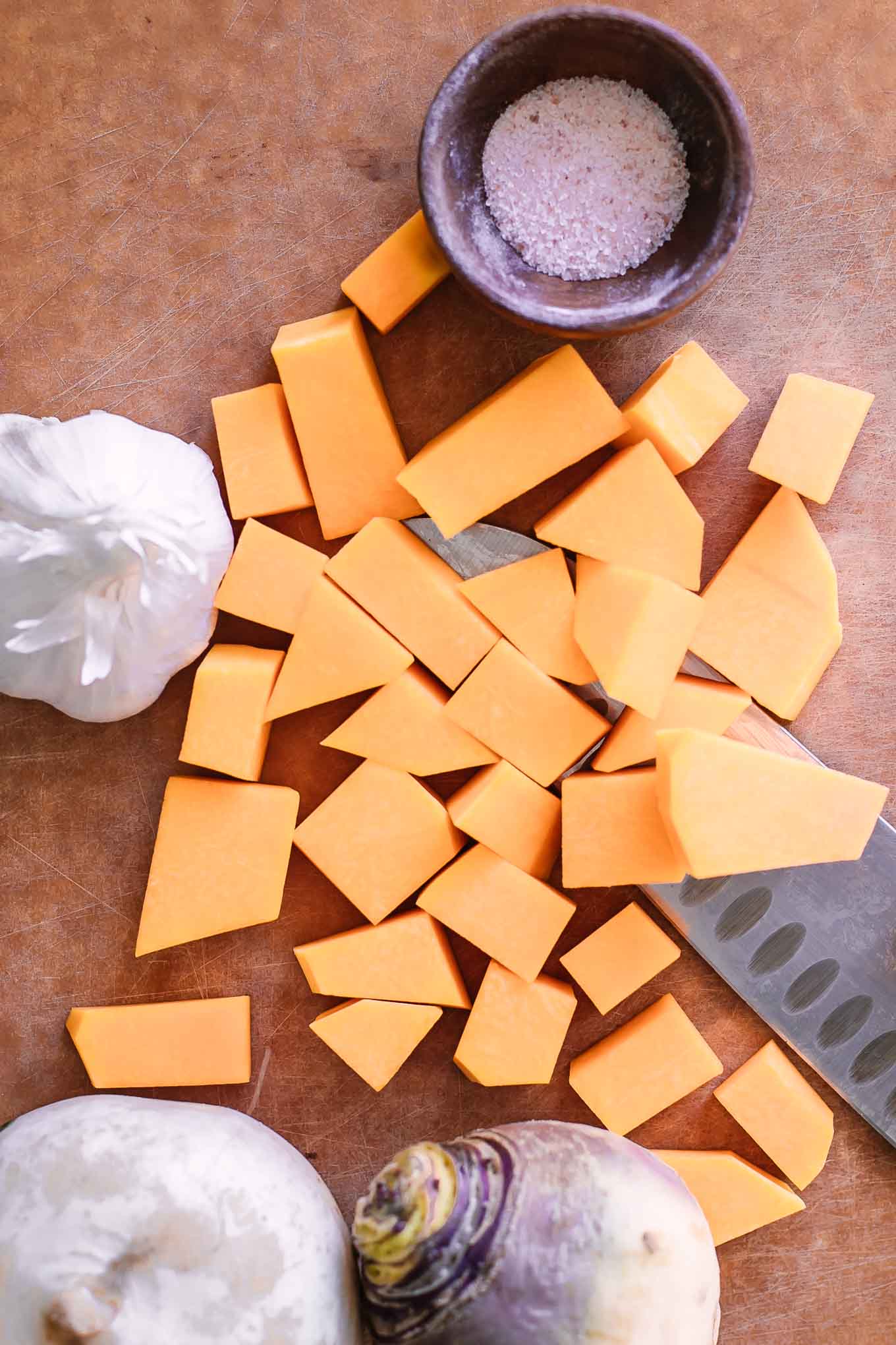 cut butternut squash and turnips on a wood cutting board