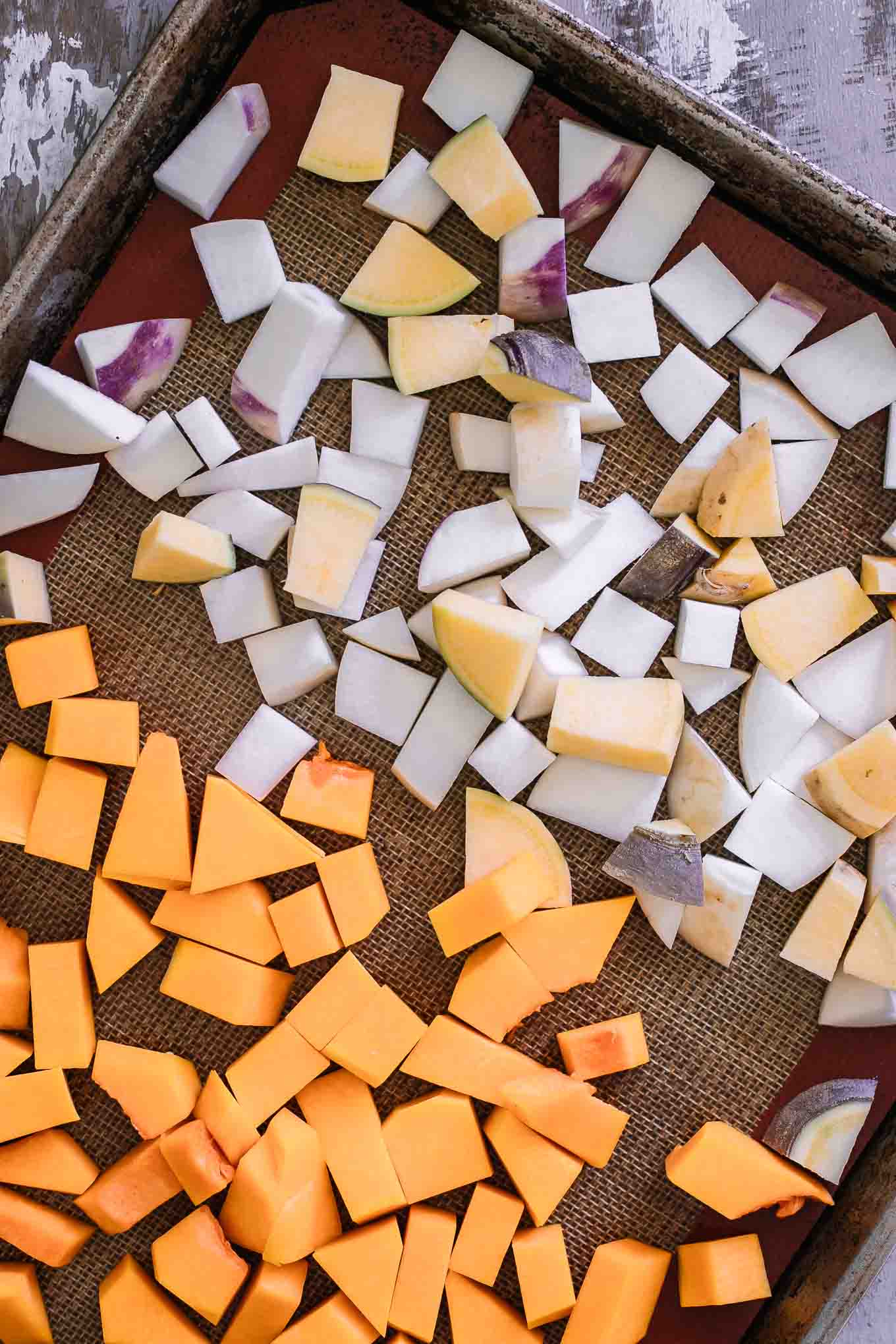 cut turnips and butternut squash on a roasting pan