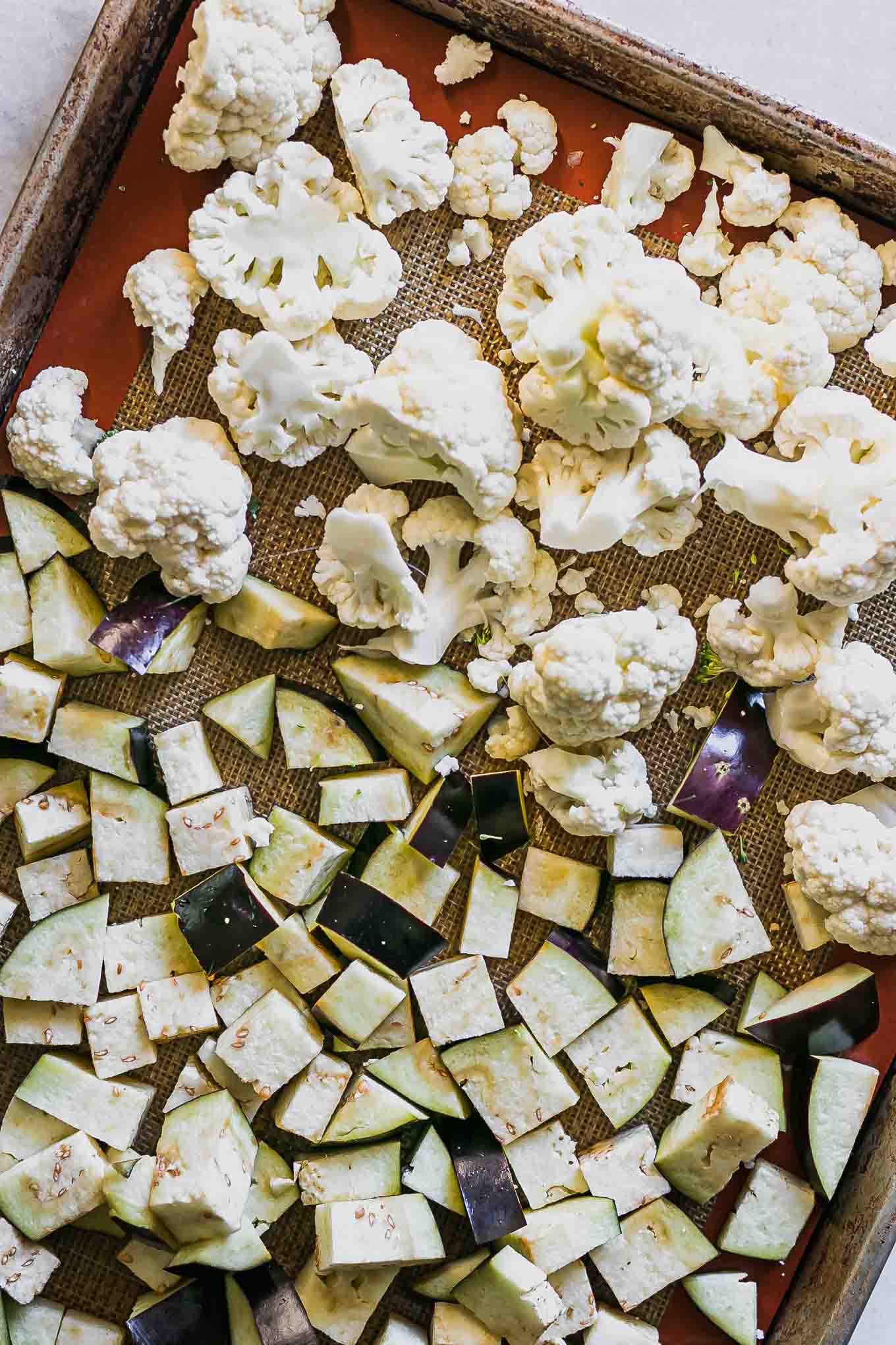 cut cauliflower and eggplant on a baking sheet before roasting