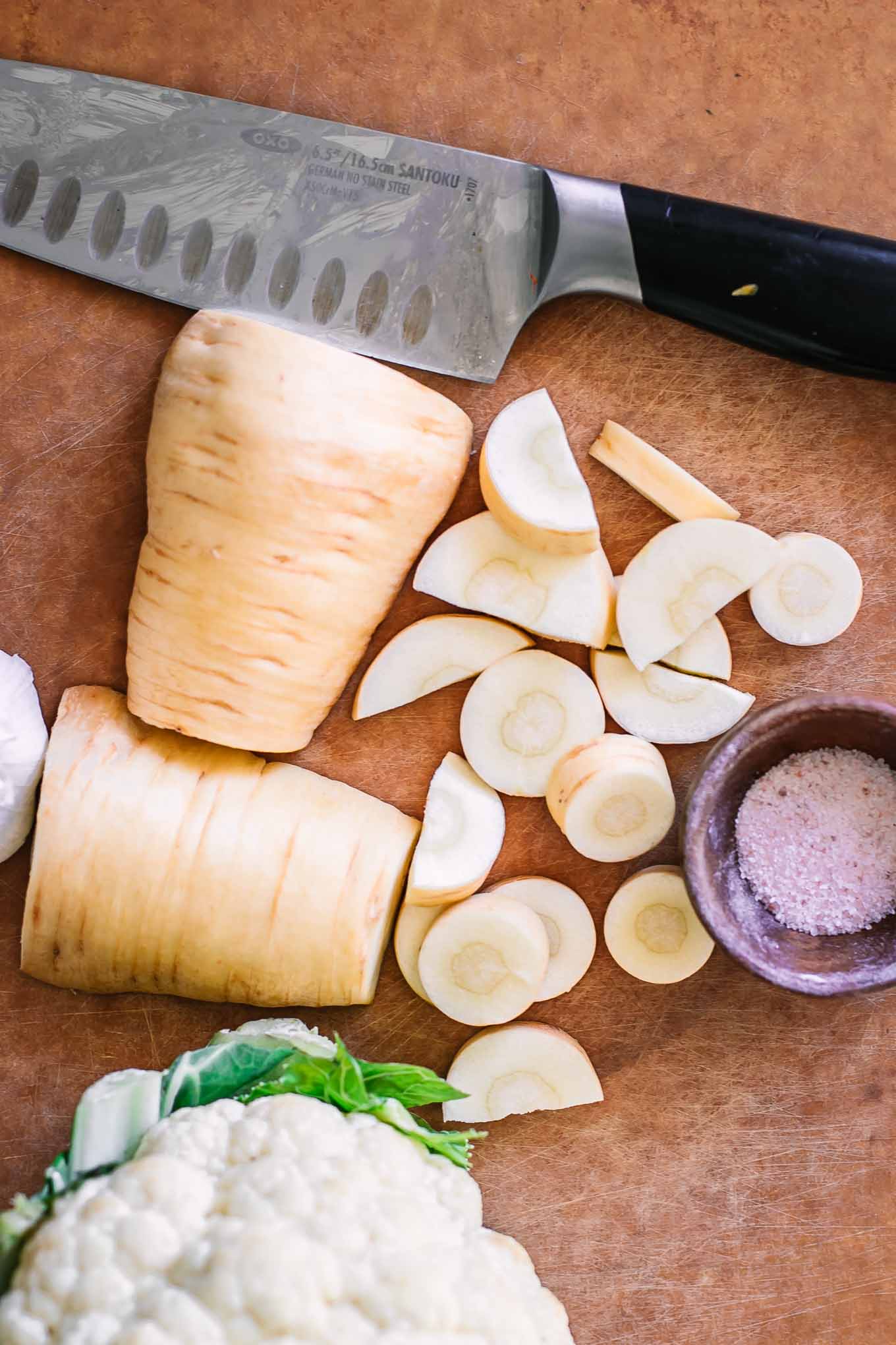 cut parsnips and cauliflower on a wood cutting board