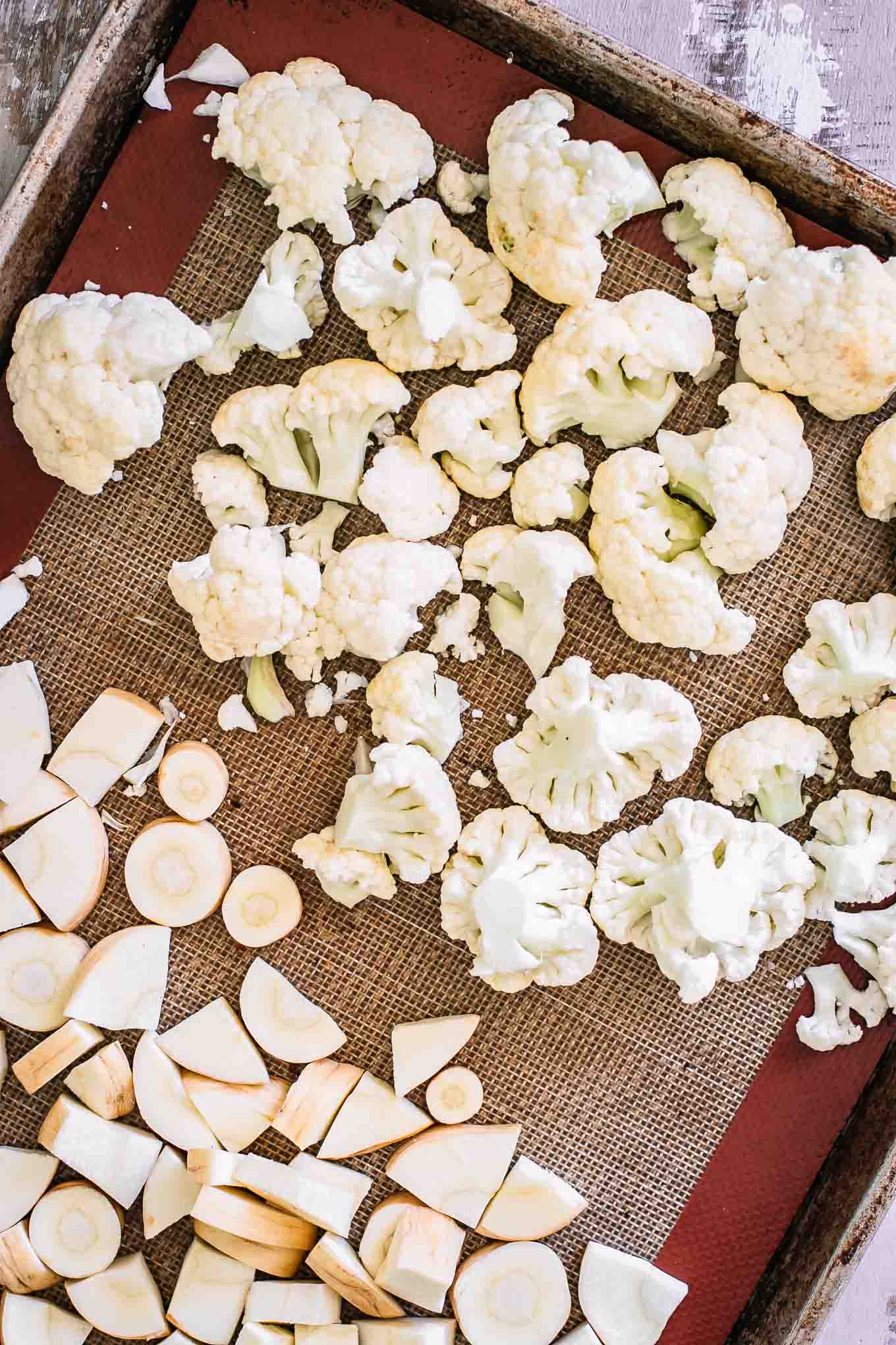 cut cauliflower and parsnips on a baking sheet before roasting