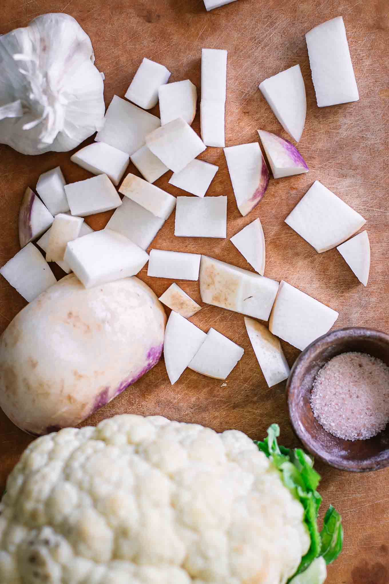 cut turnips and cauliflower on a wood cutting board