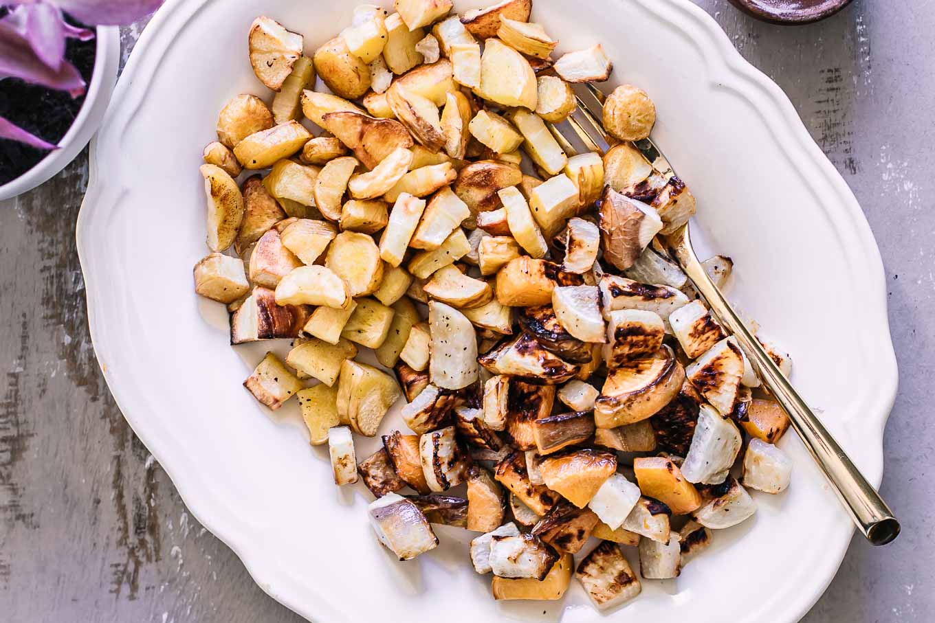 baked turnips and parsnips on a white side dish plate