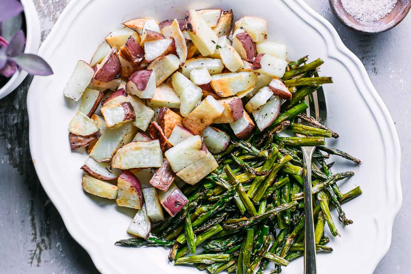 a white side dish with baked asparagus and potatoes