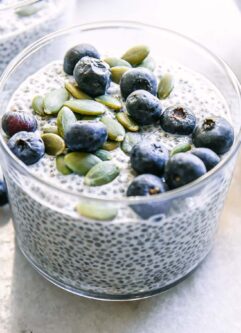 a jar of chia seed pudding with blueberries on a white countertop