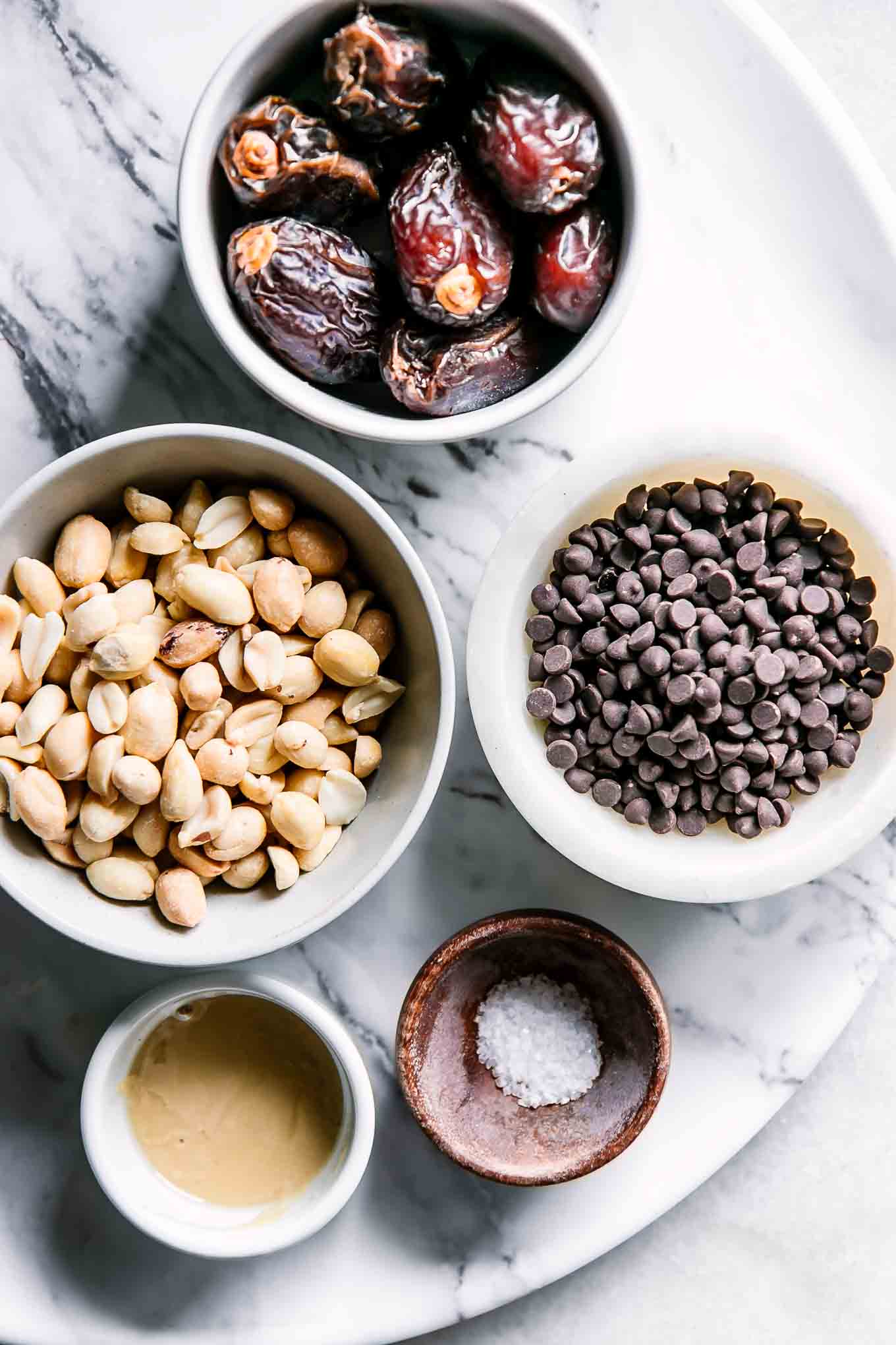 bowls of chocolate, dates, peanuts,  peanut butter, and salt for stuffed dates