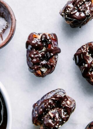dates stuffed with peanut butter and drizzled with chocolate on a white plate
