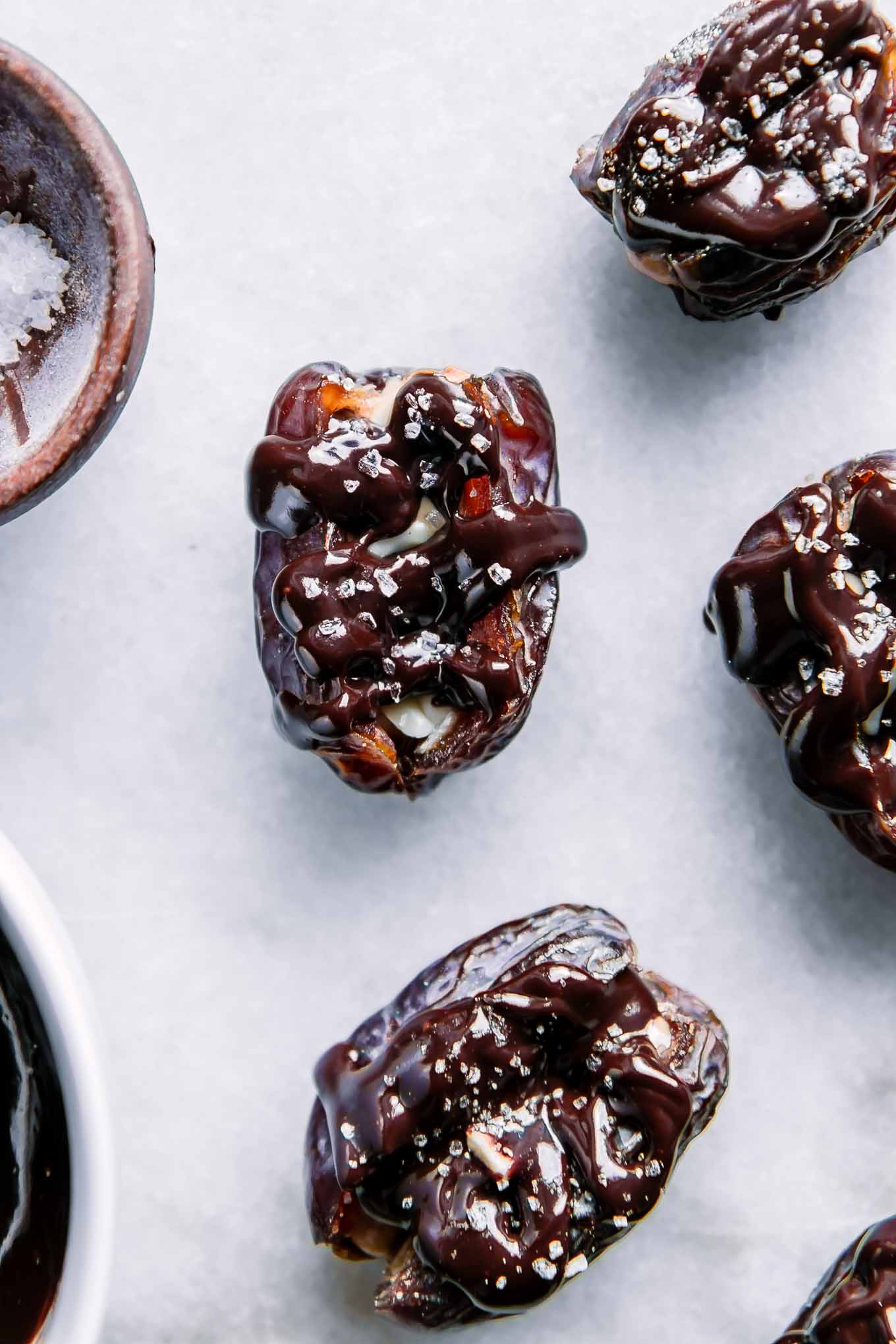 dates stuffed with peanut butter and drizzled with chocolate on a white plate