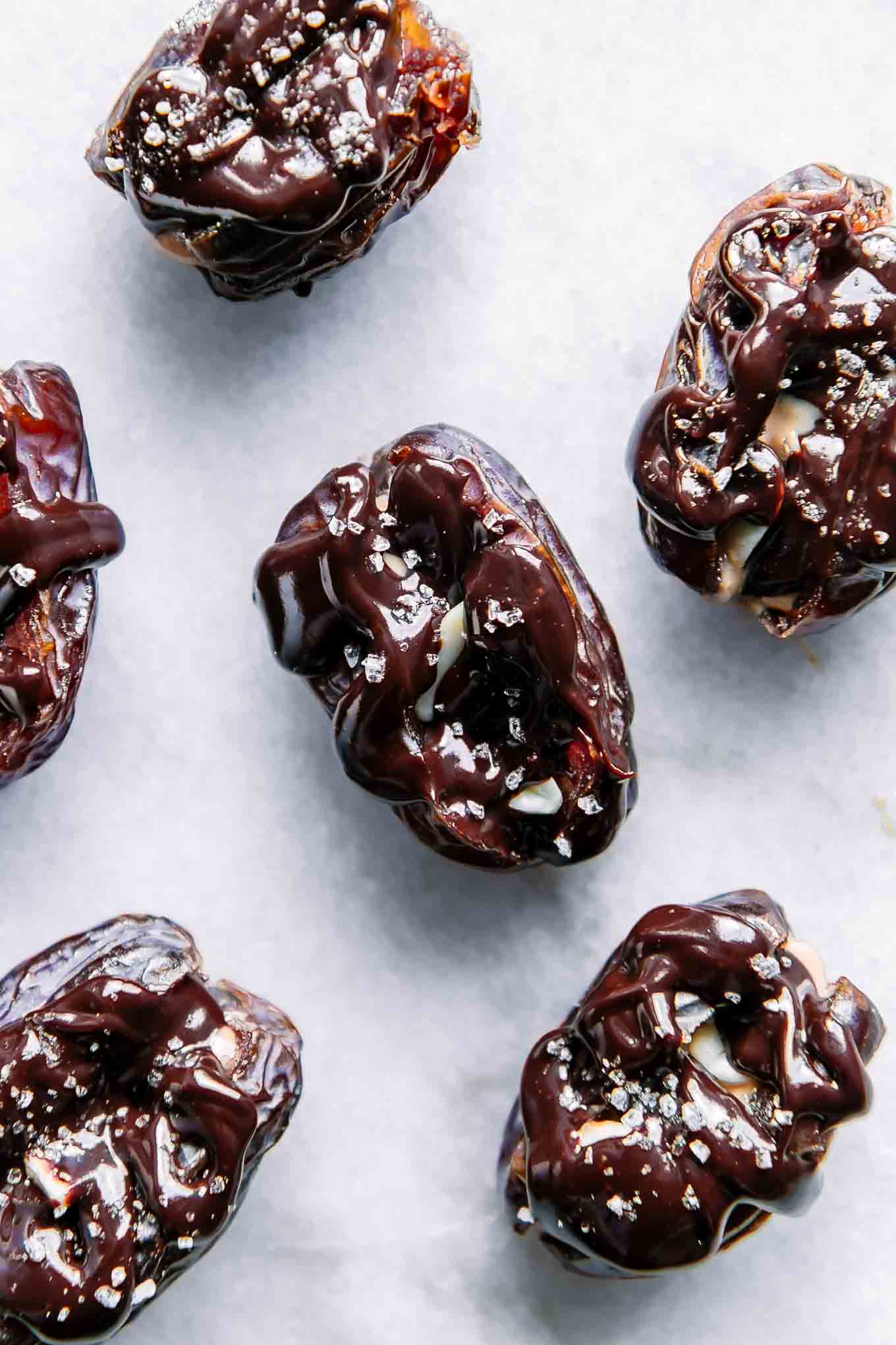 a close up photo of medjool dates stuffed with chocolate and peanut butter on a white table