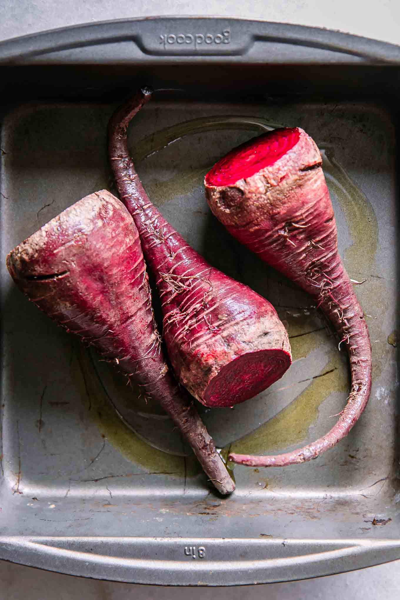 red beets inside a roasting pan before baking