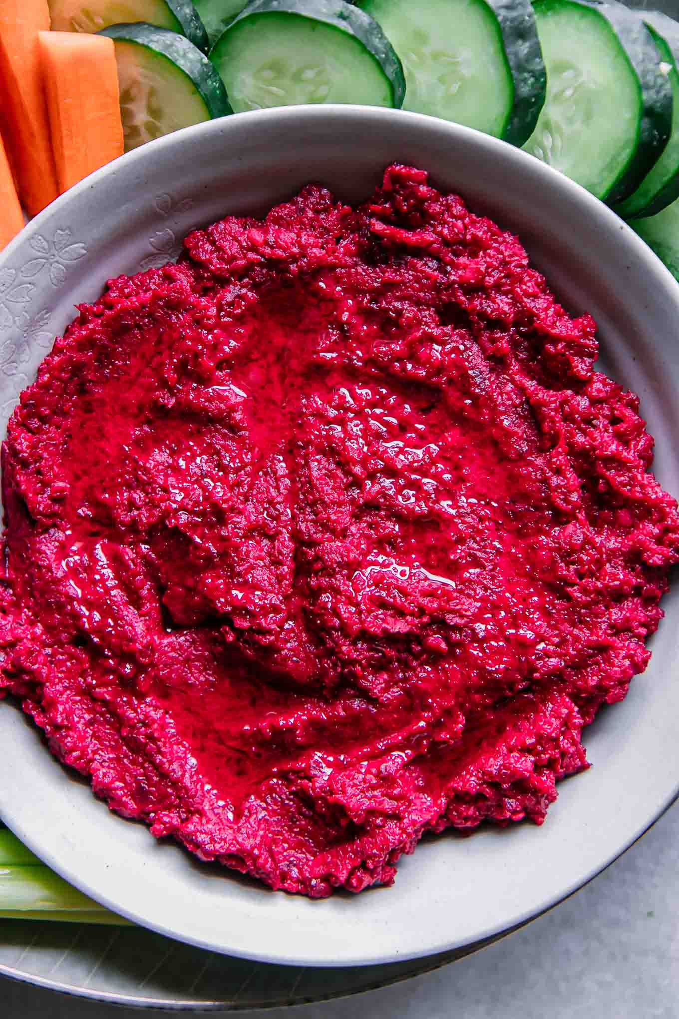 a close up photo of a bowl of red beet hummus