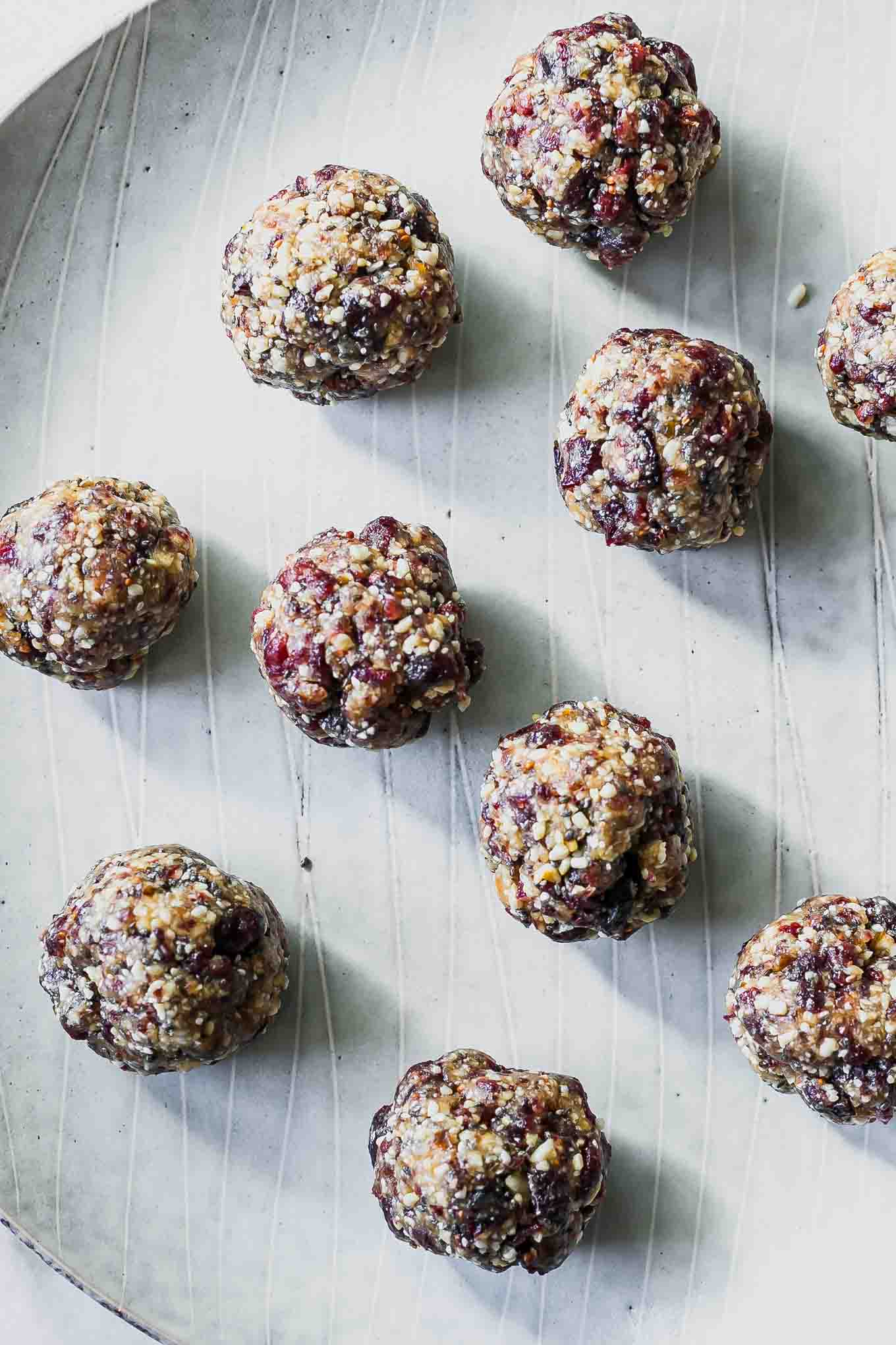 cranberry, date, and cashew snack balls on a white plate