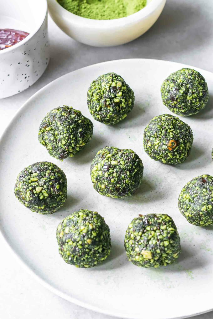 green energy ball snack bites with matcha powder on a white plate