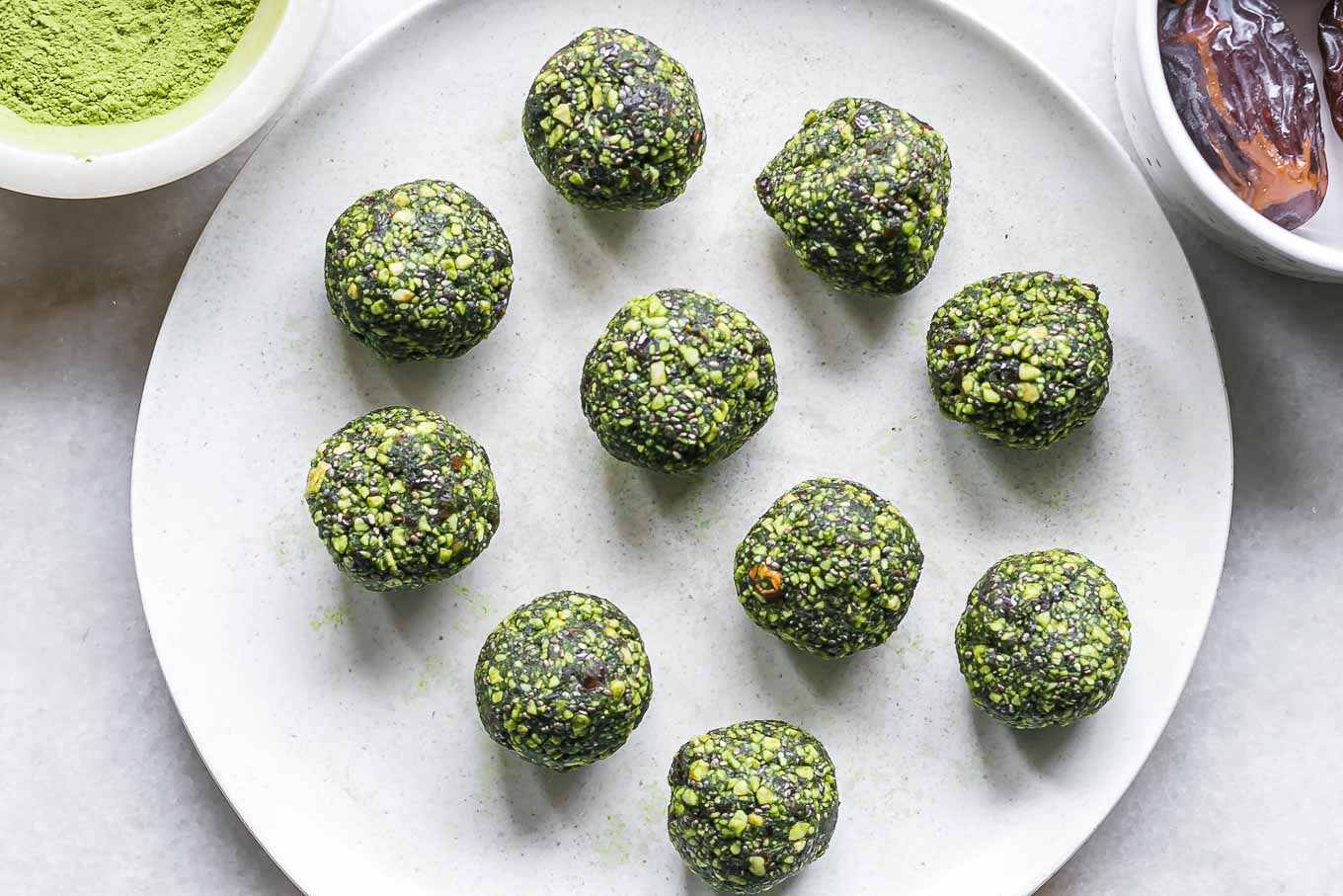 green energy balls with green tea matcha powder on a white plate
