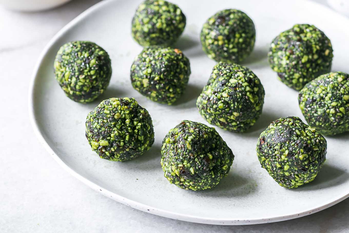 green matcha bliss balls on a white plate