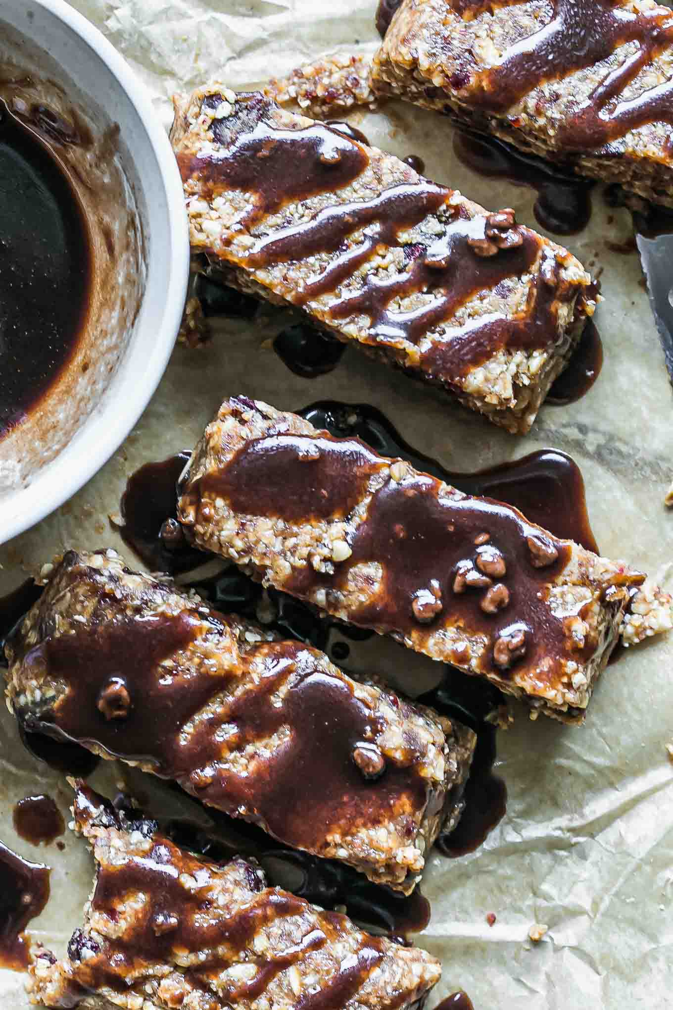 homemade granola bars with chocolate drizzled on top on parchment paper