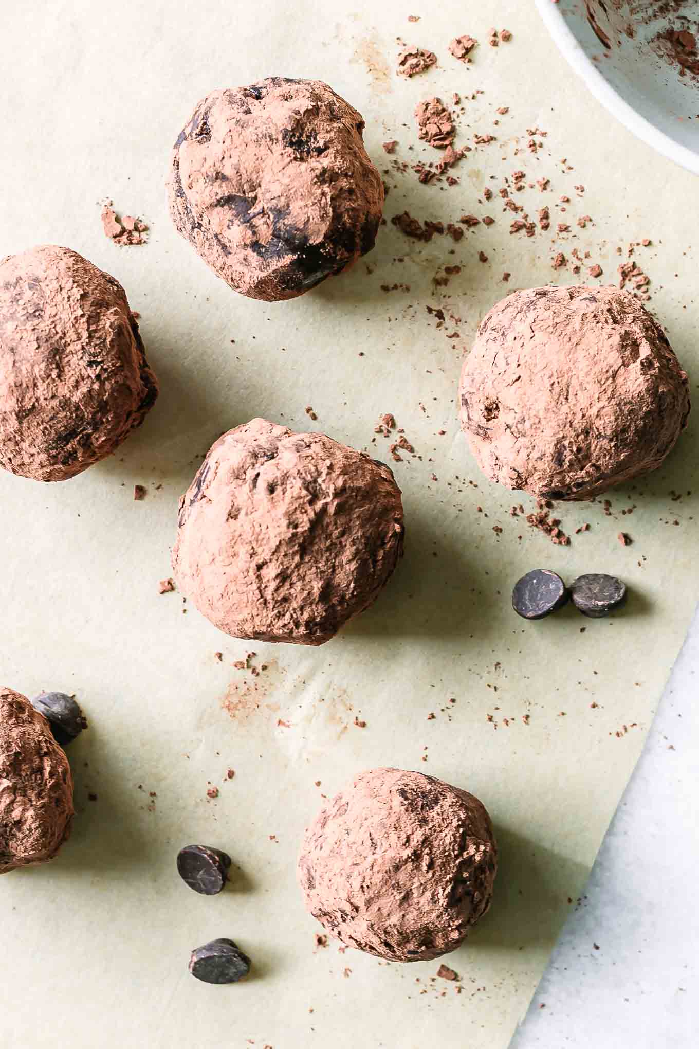 rolled brownie bite balls coated in cocoa powder on parchment paper