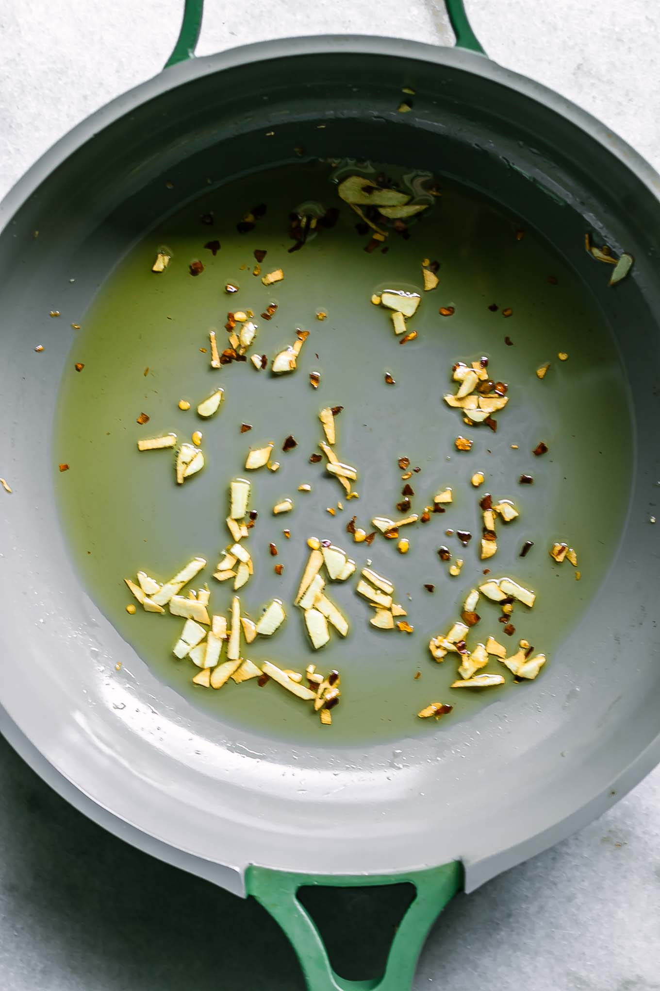 a sauce pan with oil, garlic, and red pepper flakes