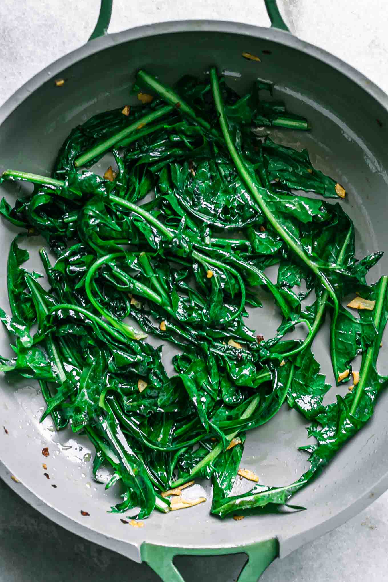 wilted and sautéed dandelion greens in a pan after cooking