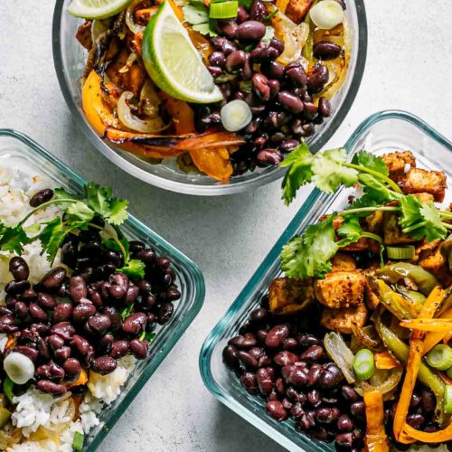 glass food storage bowls with tofu fajitas and rice on a white table for meal prep