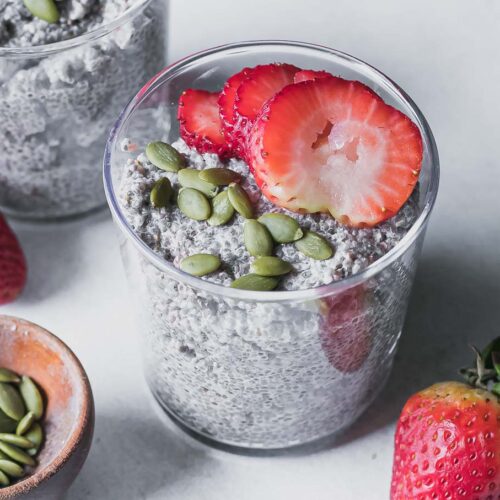 a glass jar with strawberry chia pudding on a white table