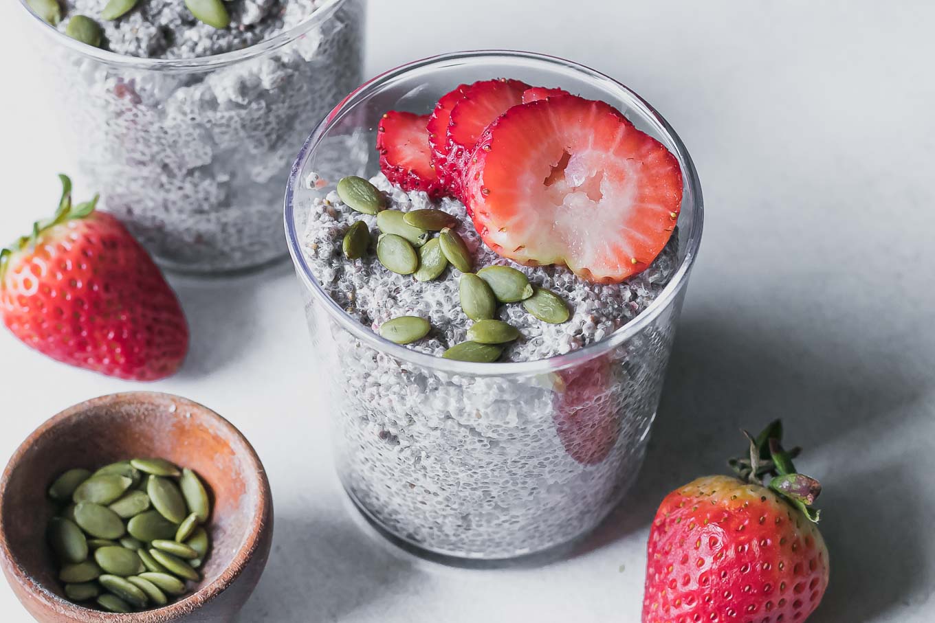a glass jar with strawberry chia pudding on a white table