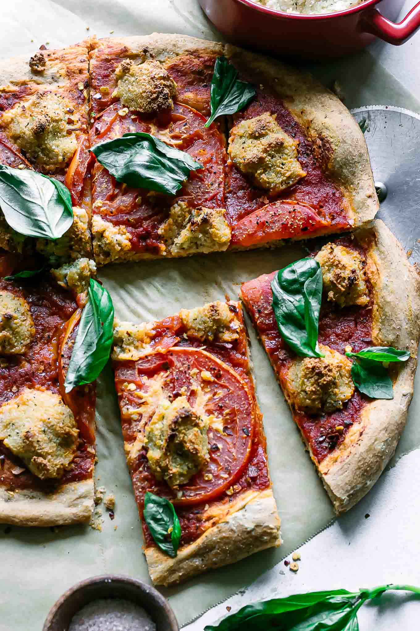 cut vegan margherita pizza on a table after baking