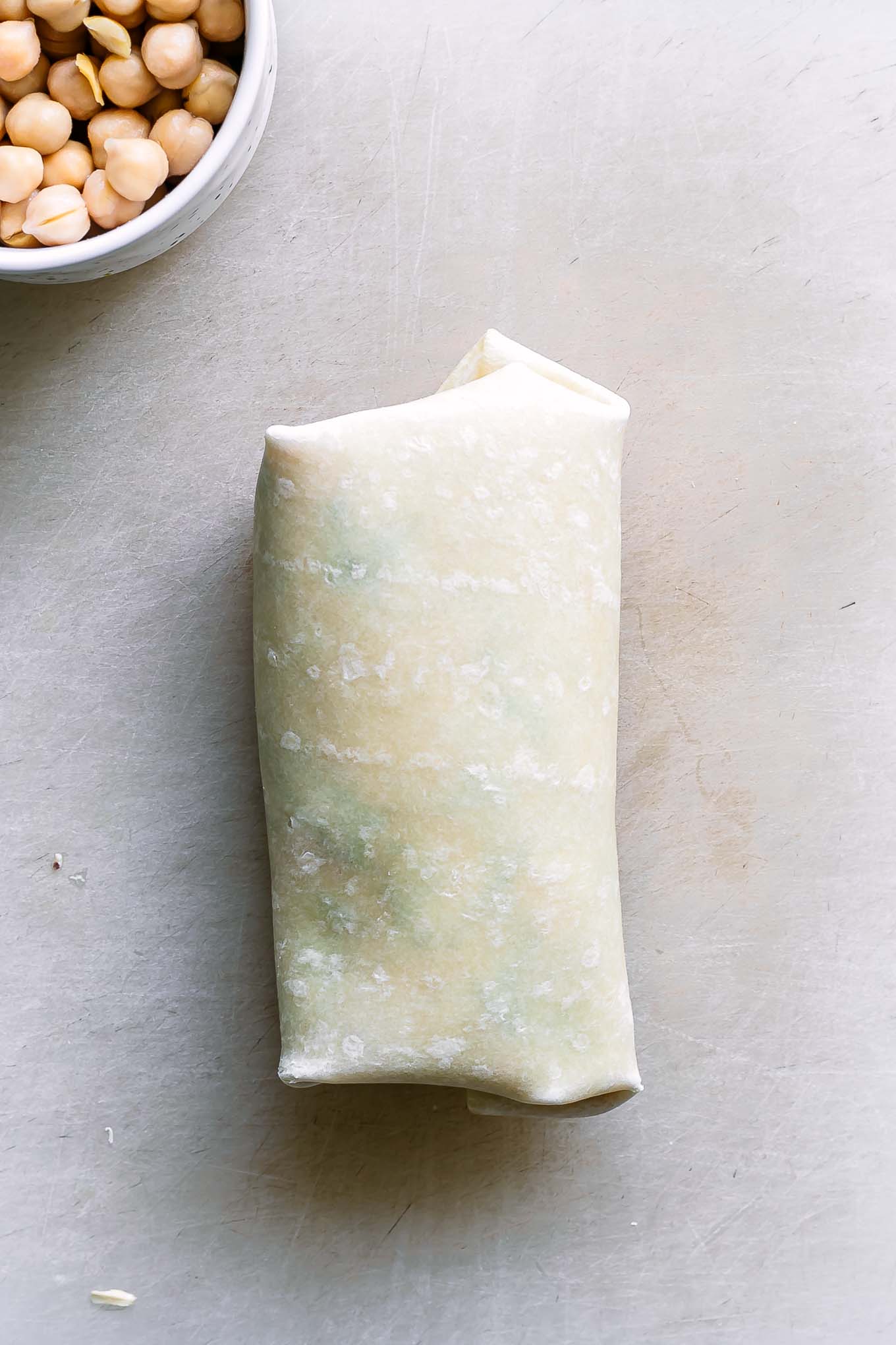 a buffalo cauliflower wrap before cutting on a cutting board
