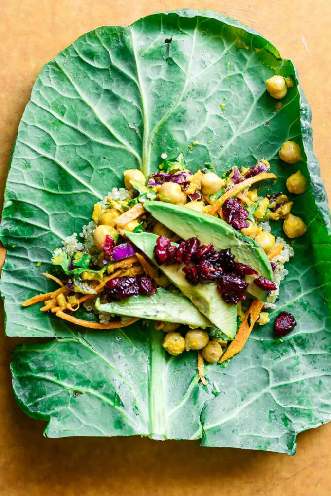 a collard wrap with chickpea quinoa salad and avocado slices on a cutting board