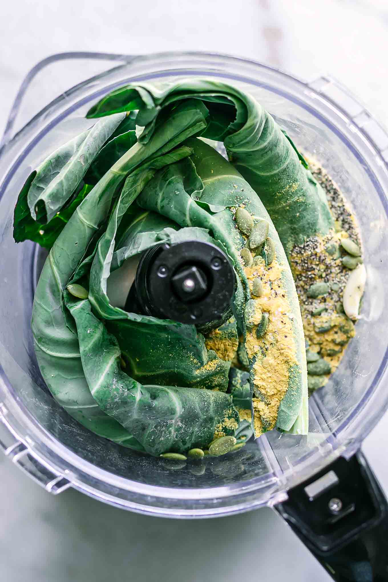 collard greens, cheese, nuts, garlic, and spices in a food processor before blending