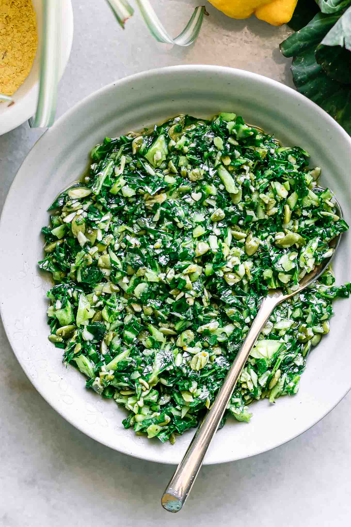 collard greens pesto in a white bowl with a gold fork