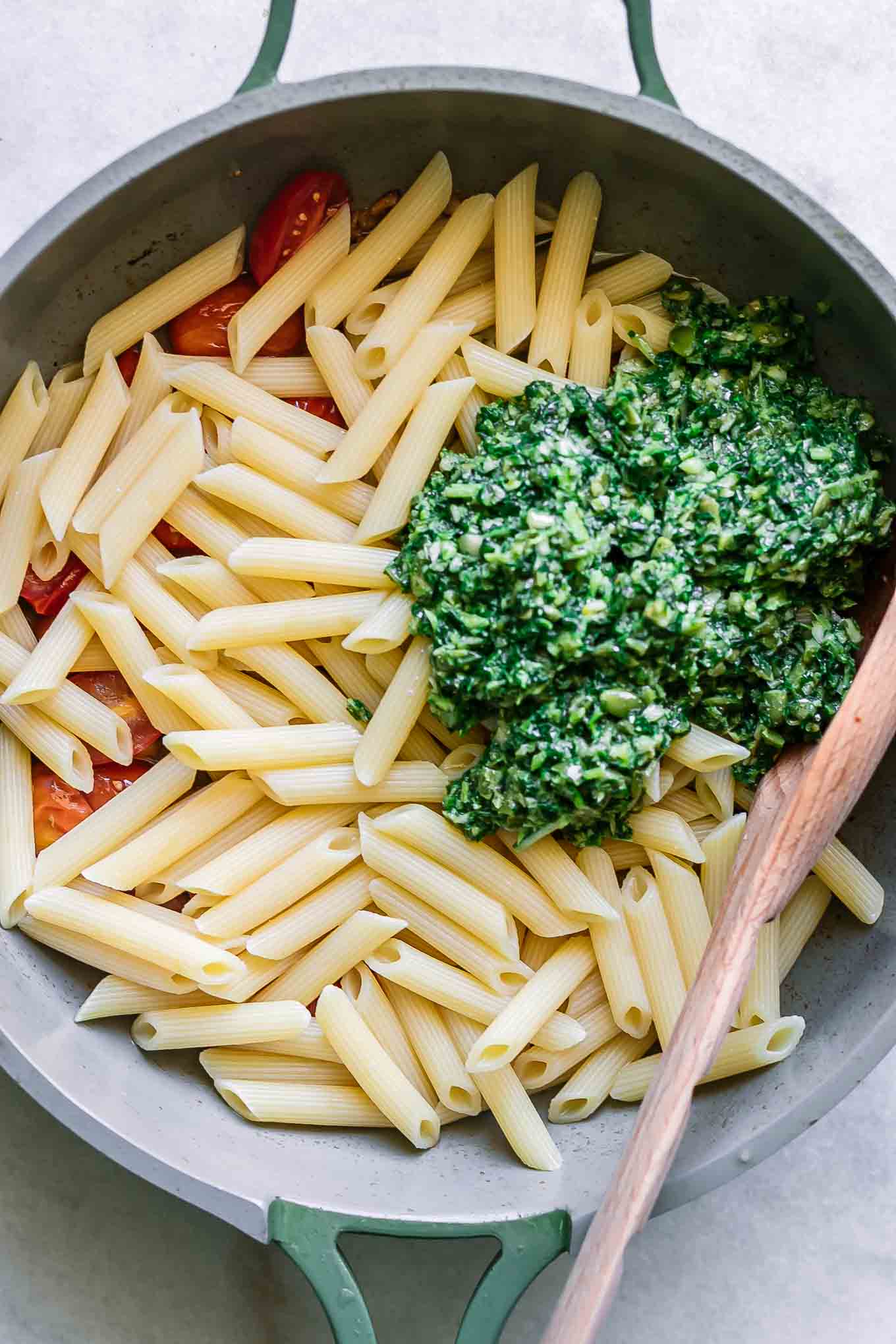 penne pasta, cherry tomatoes, and pesto sauce in a pan