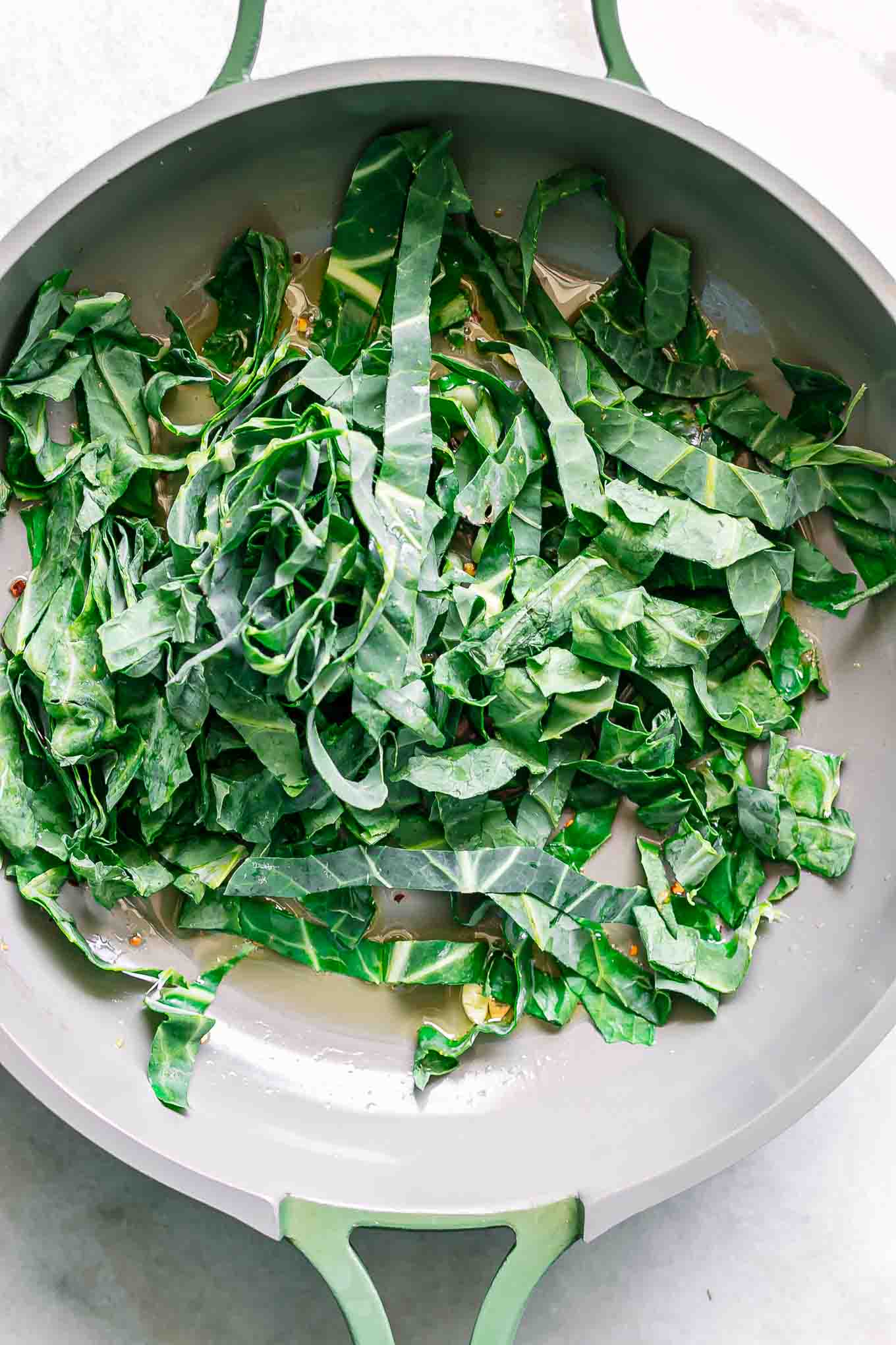 sliced collard greens cooking inside a pan