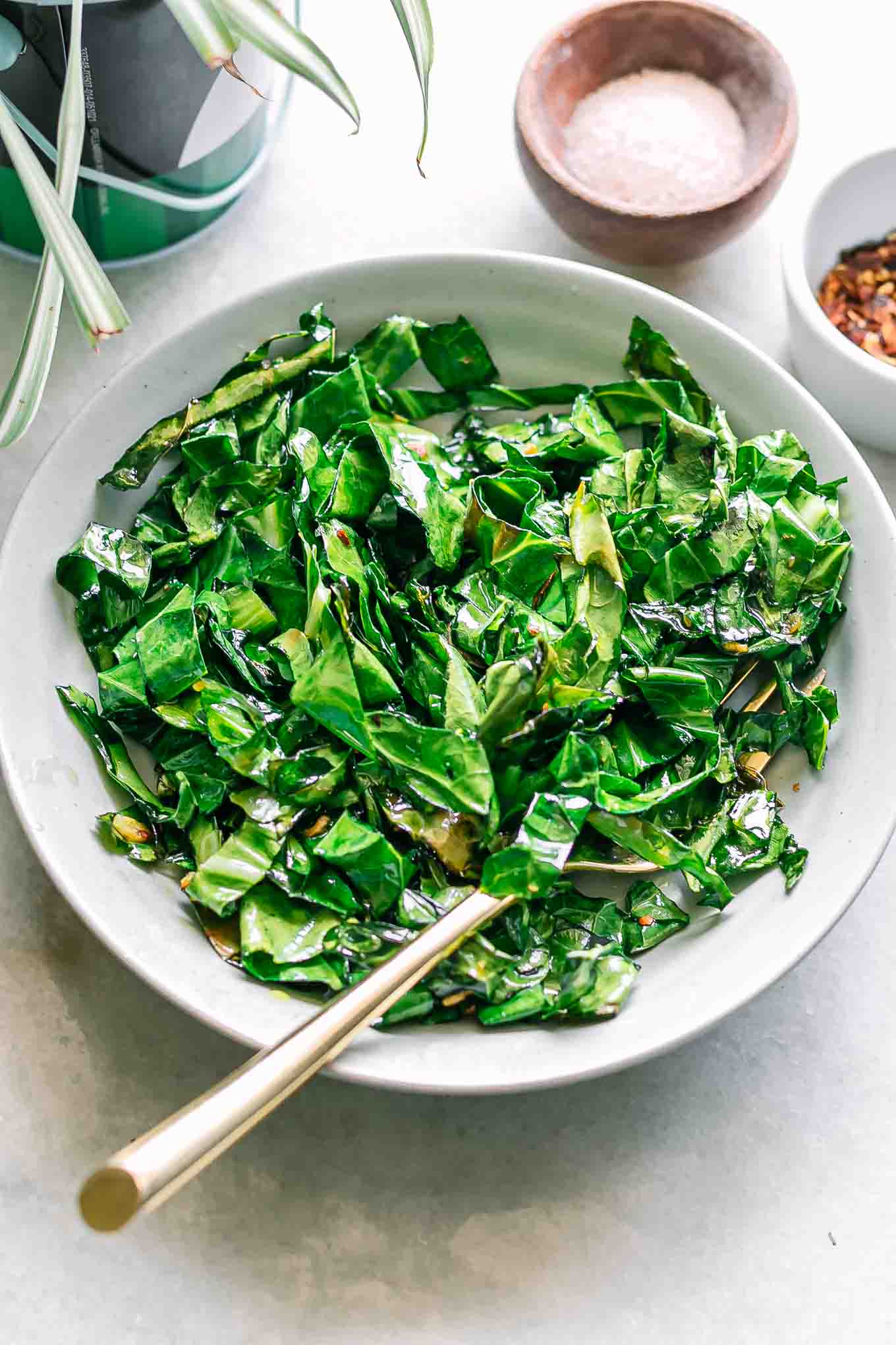 a bowl of pan fried collard greens on a white table