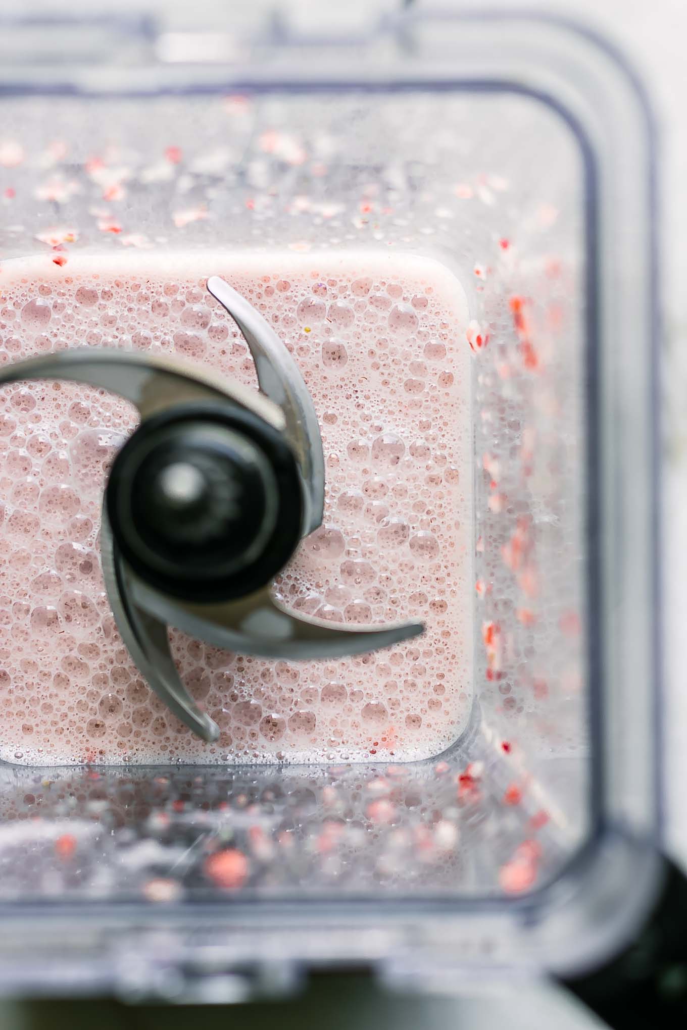 a blender with strawberry flavored milk for overnight oats