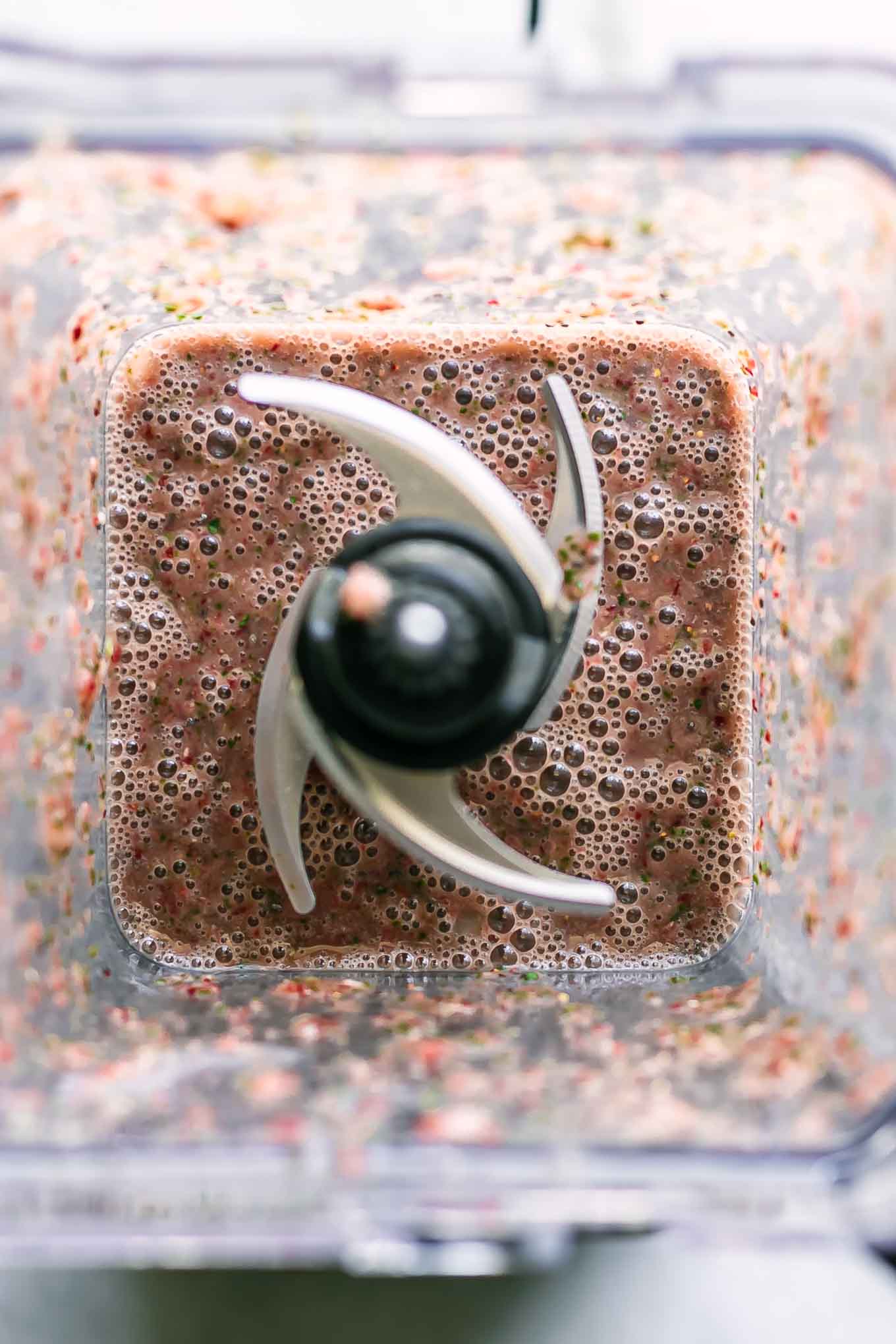 a strawberry spinach smoothie inside a blender after mixing