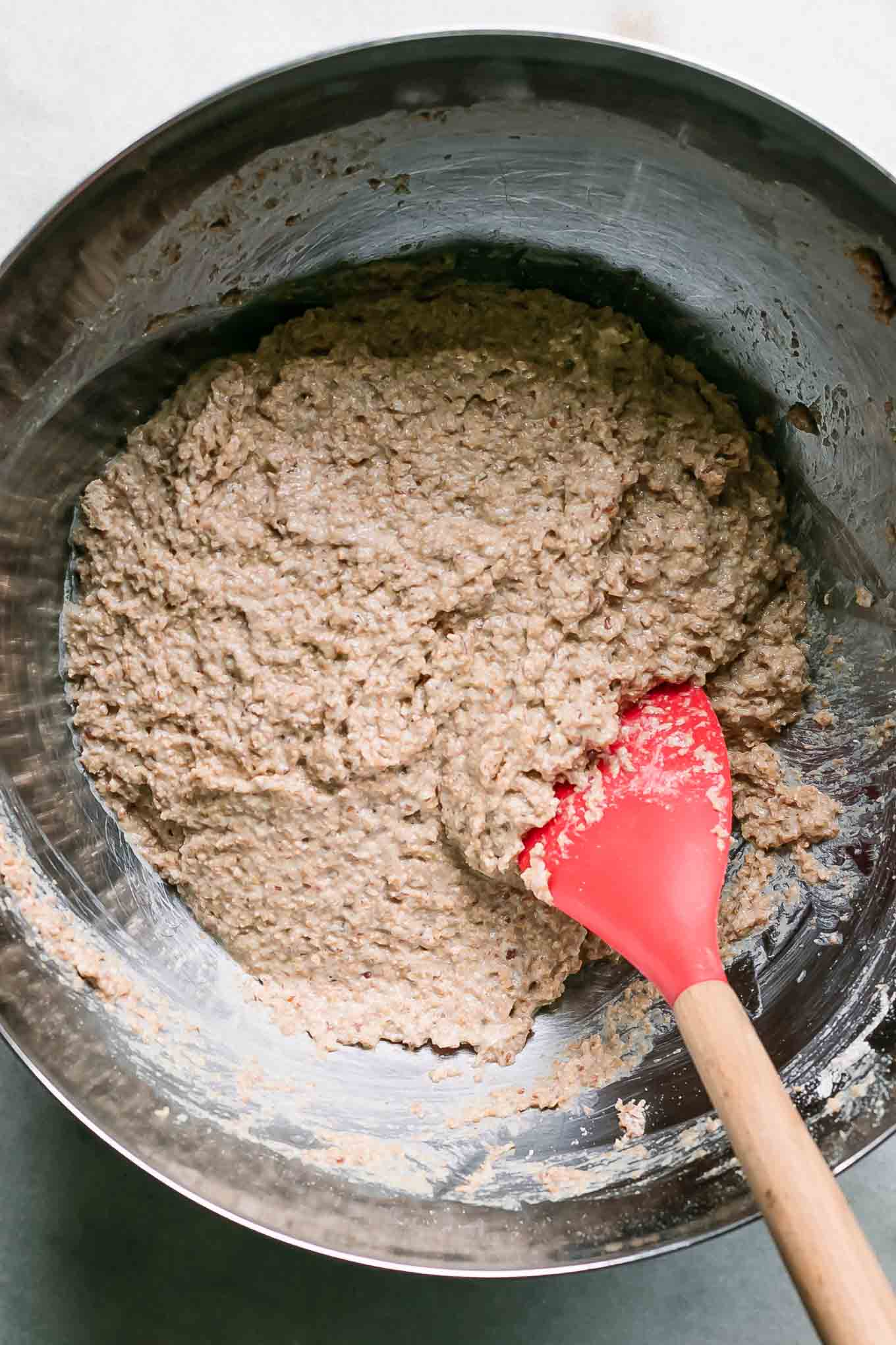 a large mixing bowl with bran muffin batter inside with a baking spatula