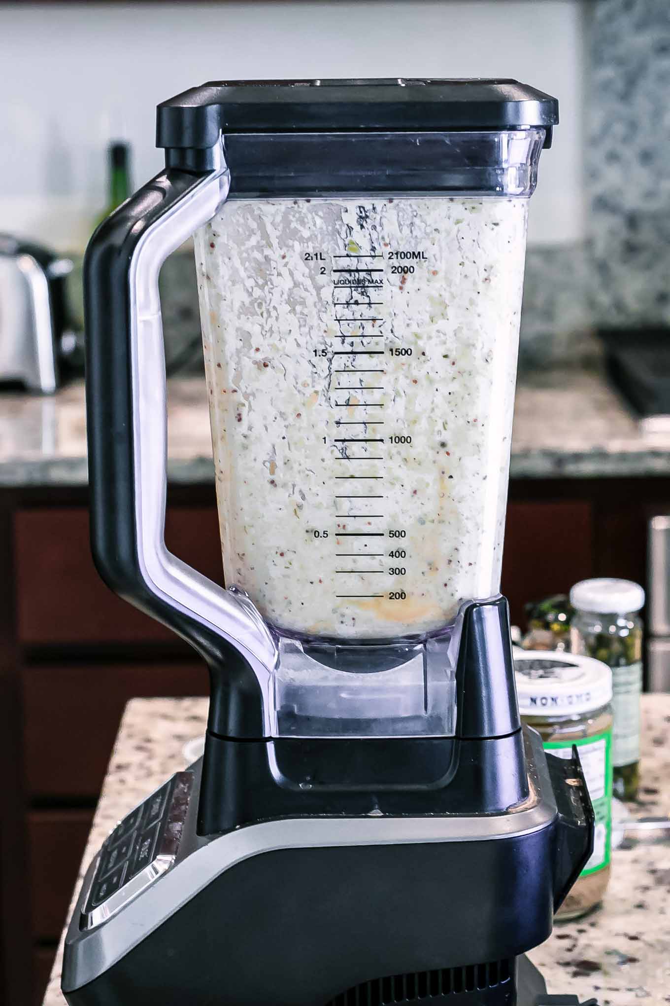 a blender with vegan caesar dressing on a counter top
