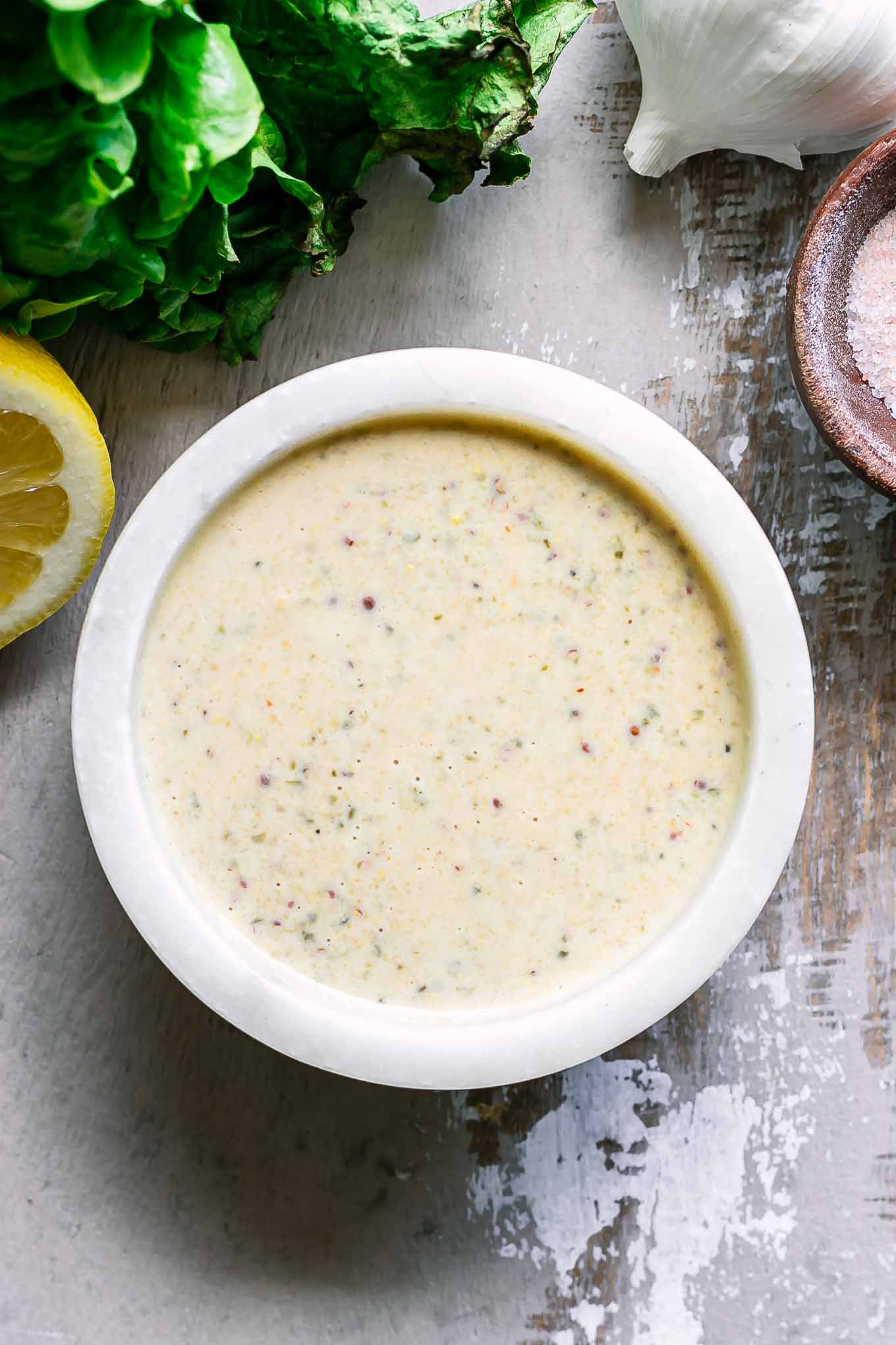 a close up photo of a bowl of plant-based caesar dressing on a table