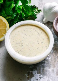 a bowl of vegan caesar dressing in a white bowl on a wood table