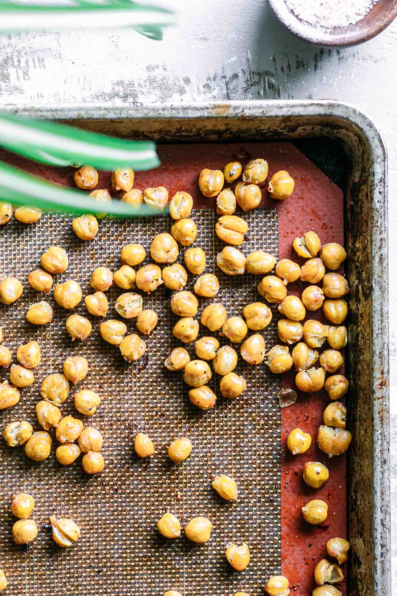 a roasting pan with crispy baked chickpeas on a white table