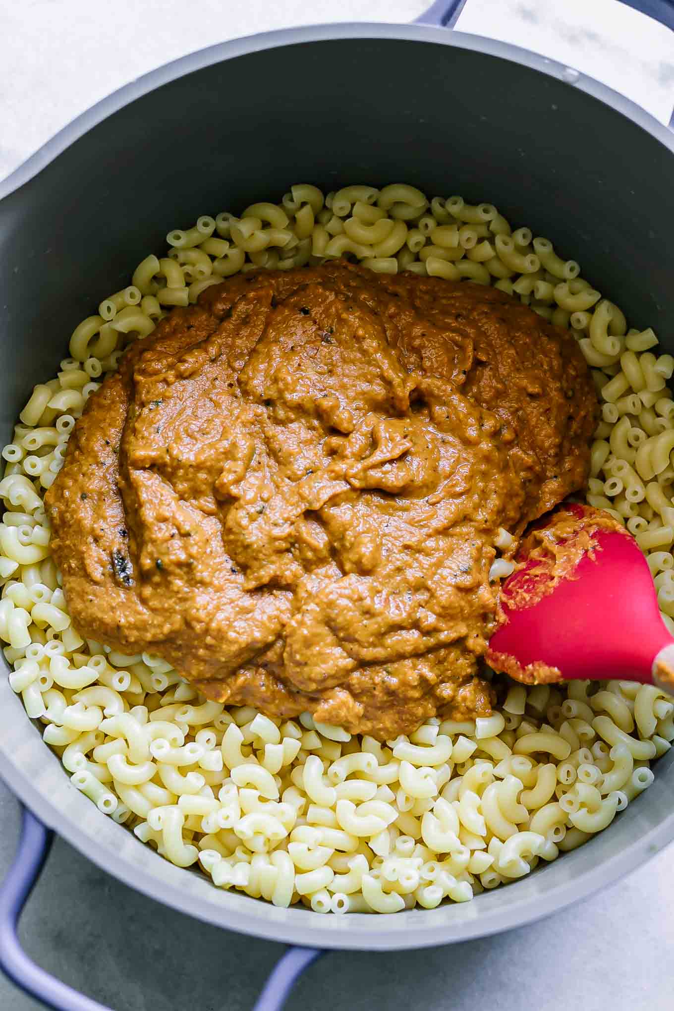 a pot with cooked macaroni and sweet potato cheese sauce
