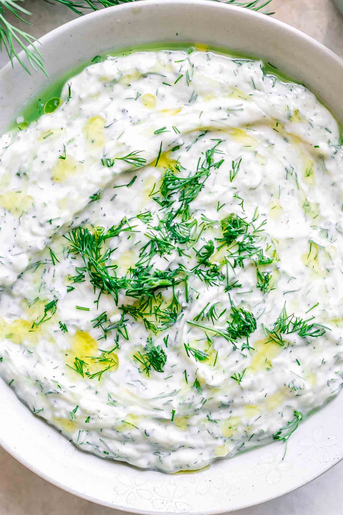 a close up photo of plant-based tzatziki sauce in a white bowl