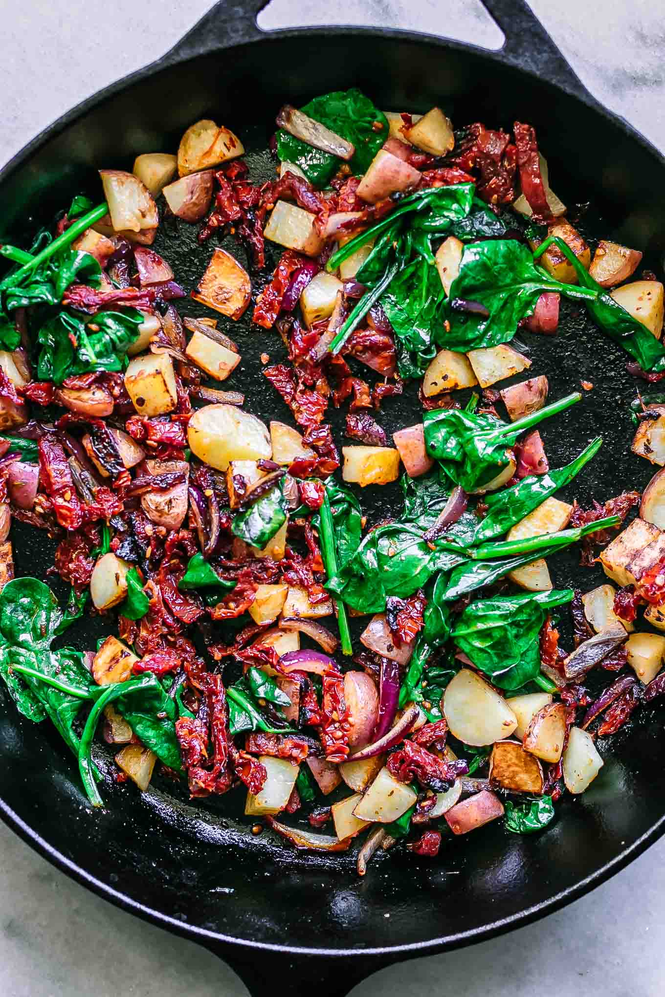 a cast iron skillet with cooked vegetables