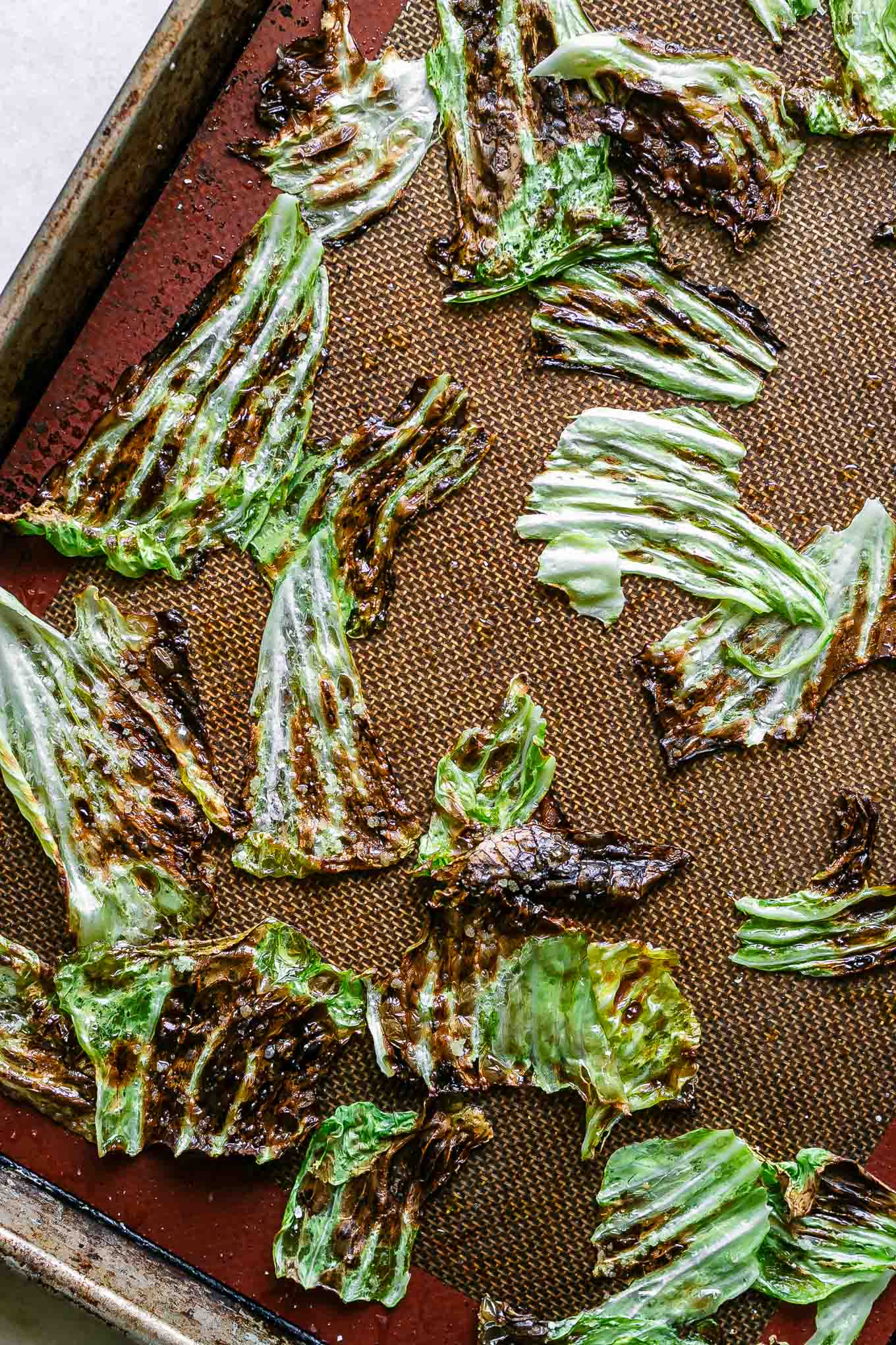 crispy baked cabbage leaves chips on a baking sheet after roasting