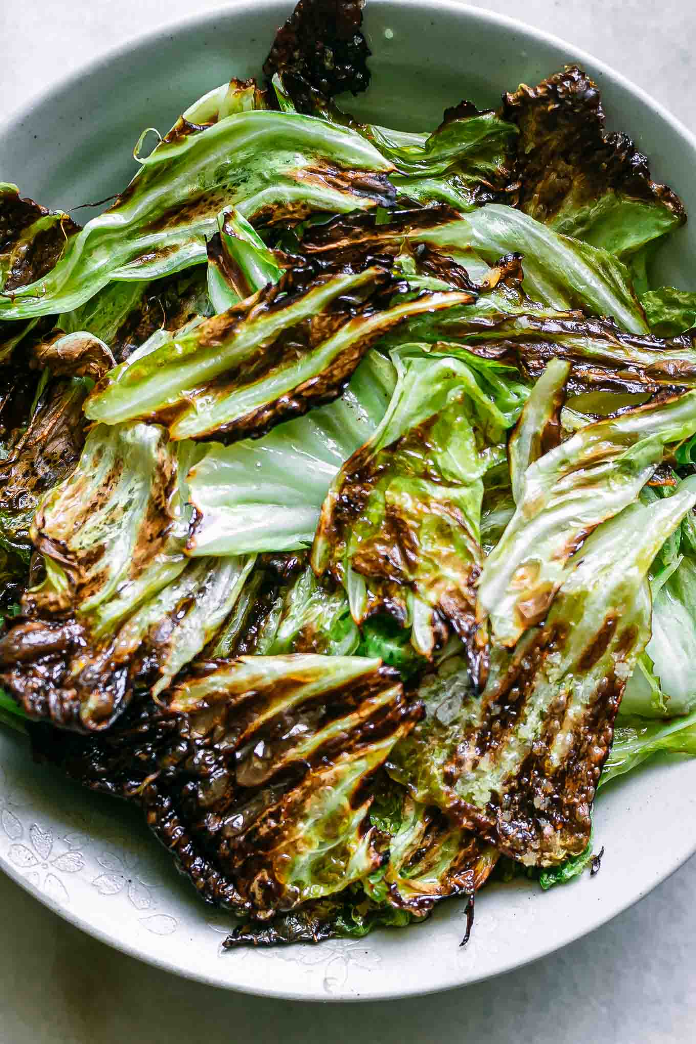 a close up photo of roasted cabbage leaves on a plate