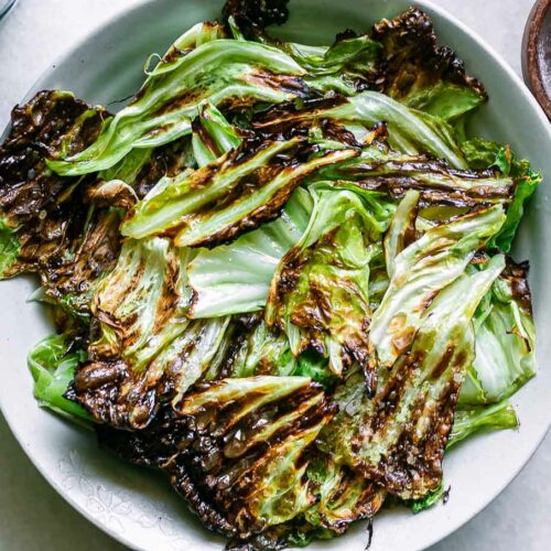 crispy baked cabbage leaves chips in a bowl on a white table
