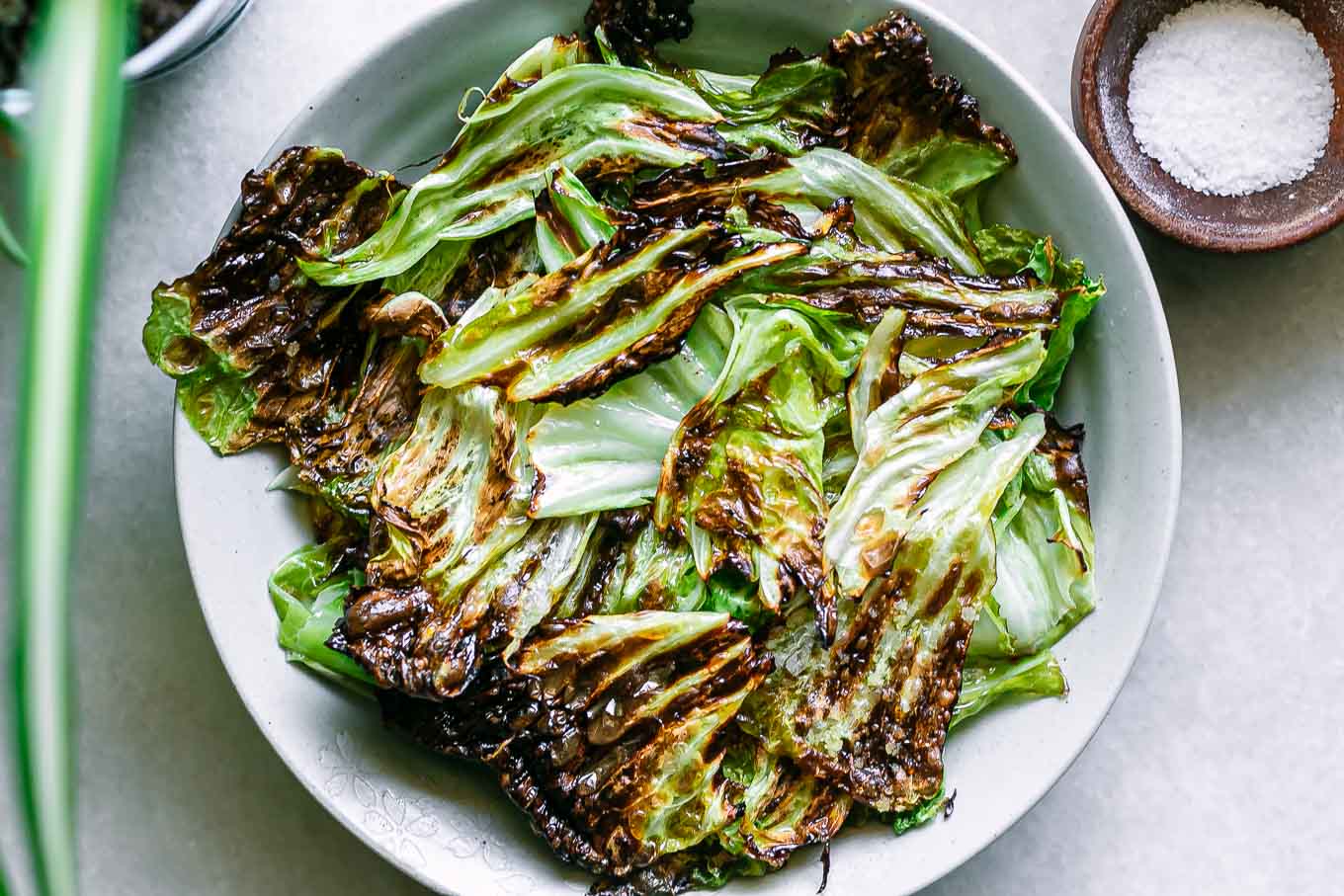 crispy baked cabbage leaves chips in a bowl on a white table