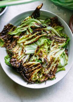 baked cabbage chips on a blue plate on a white table